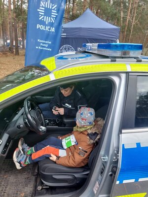 policjantka pokazująca dziecku wyposażenie radiowozu policyjnego