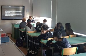 Policjantka i uczniowie podczas zajęć w klasie szkolnej.