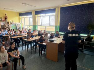 Policjantka i uczniowie podczas zajęć w klasie szkolnej.
