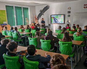 POLICJANTKA I DZIECI PODCZAS ZAJĘĆ W SZKOLE.