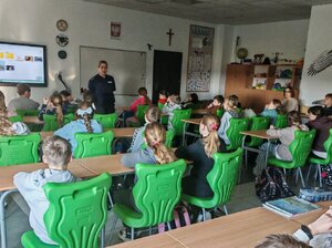 POLICJANTKA I DZIECI PODCZAS ZAJĘĆ W SZKOLE.