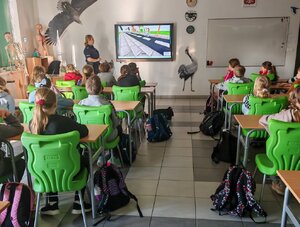 POLICJANTKA I DZIECI PODCZAS ZAJĘĆ W SZKOLE.