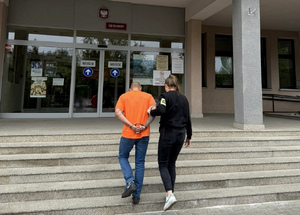 policjantka trzymająca zatrzymanego