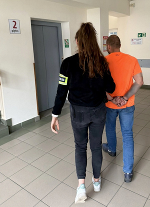 policjantka trzymająca zatrzymanego