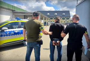 policjanci trzymają zatrzymanego