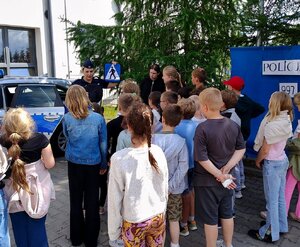 Policjantka podczas rozmów z uczniami na terenie przyszkolnym.