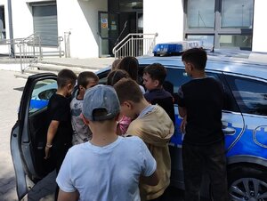 Policjantka podczas rozmów z uczniami na terenie przyszkolnym.