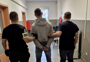 policjanci prowadzą zatrzymanego