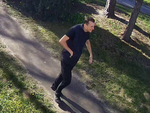 wizerunek podejrzewanego mężczyzny idącego po terenie zielonym