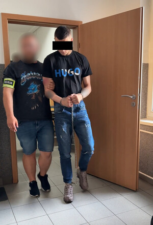 policjant prowadzi zatrzymanego