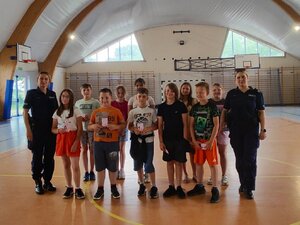 Policjantki i uczniowie podczas spotkania w auli szkolnej.