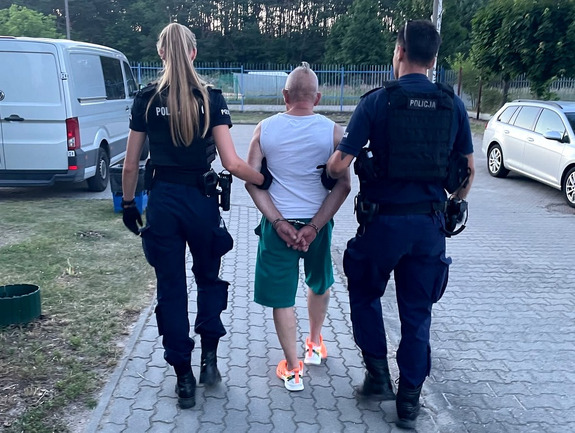 Policjanci prowadzą zatrzymanego.