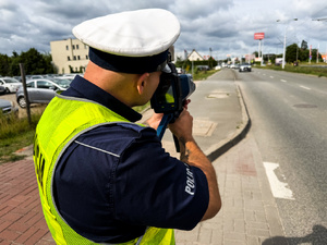Policjanci mierzący prędkość i podejmujący kontrole drogowe