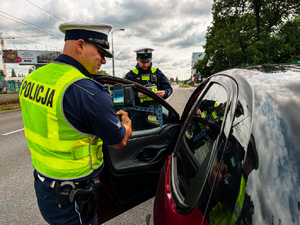 Policjanci mierzący prędkość i podejmujący kontrole drogowe