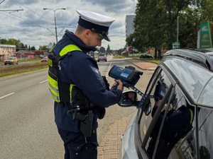 Policjanci mierzący prędkość i podejmujący kontrole drogowe