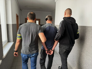 policjanci prowadzą zatrzymanego