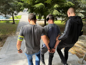 policjanci prowadzą zatrzymanego