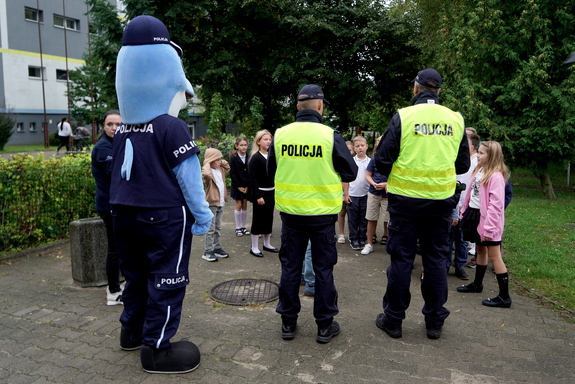 Policjanci i uczniowie podczas zajęć w rejonie przejścia dla pieszych.