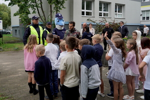 Policjanci i uczniowie podczas zajęć w rejonie przejścia dla pieszych.