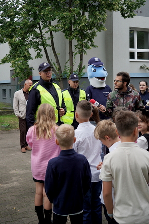 Policjanci i uczniowie podczas zajęć w rejonie przejścia dla pieszych.