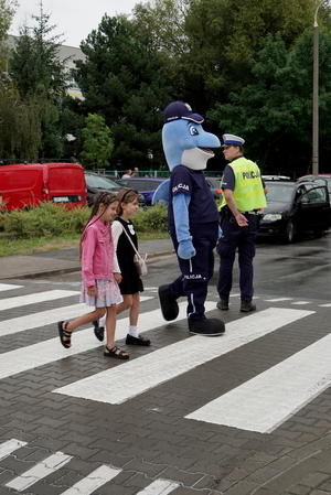 Policjanci i uczniowie podczas zajęć w rejonie przejścia dla pieszych.