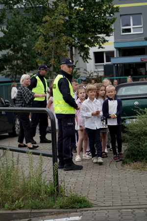 Policjanci i uczniowie podczas zajęć w rejonie przejścia dla pieszych.