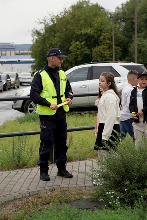 Policjanci i uczniowie podczas zajęć w rejonie przejścia dla pieszych.