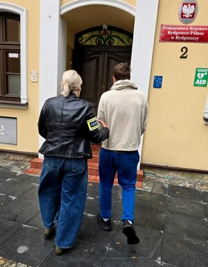 policjantka prowadzi zatrzymanego