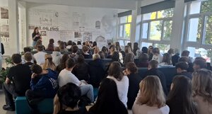 Policyjny profilaktyk i uczniowie podczas prelekcji w sali szkoły.